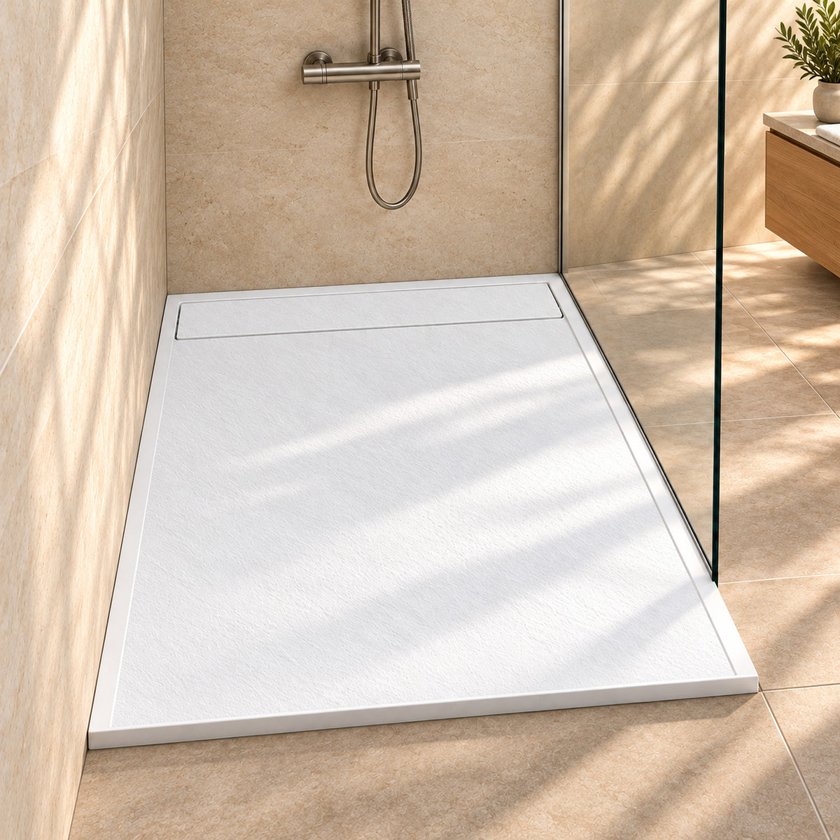 Weiße SMC-Duschwanne 140x90 cm in Schieferoptik mit langer Ablaufabdeckung, silberfarbener Armatur und Holzwaschtisch.