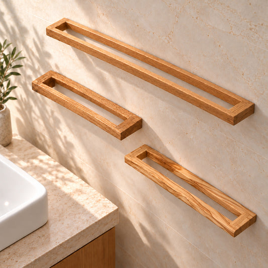 Drei Handtuchhalter an einer hellen Badwand: Eiche in 40 und 60 cm sowie Olivenholz in 40 cm.