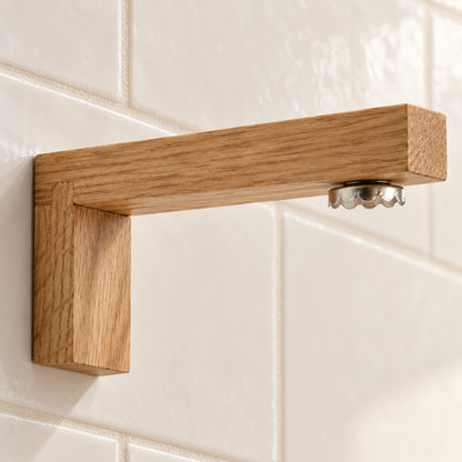 Nahaufnahme des Magnet-Seifenhalters aus Eichenholz mit sichtbarer Steckverbindung und metallischem Seifenplättchen an einer hellen Fliesenwand.
