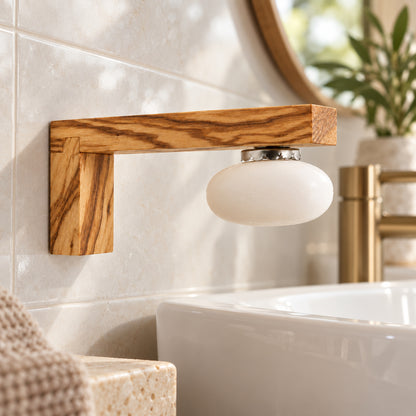 Magnet-Seifenhalter aus Olivenholz mit magnetisch gehaltener weißer Seife an einer hellen Fliesenwand neben dem Waschbecken.