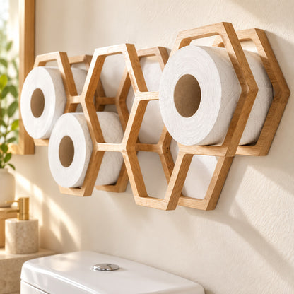 Wandmontierter Ersatzrollenhalter aus Holz in Wabenform mit weißen Toilettenpapierrollen in einem hellen Badezimmer.