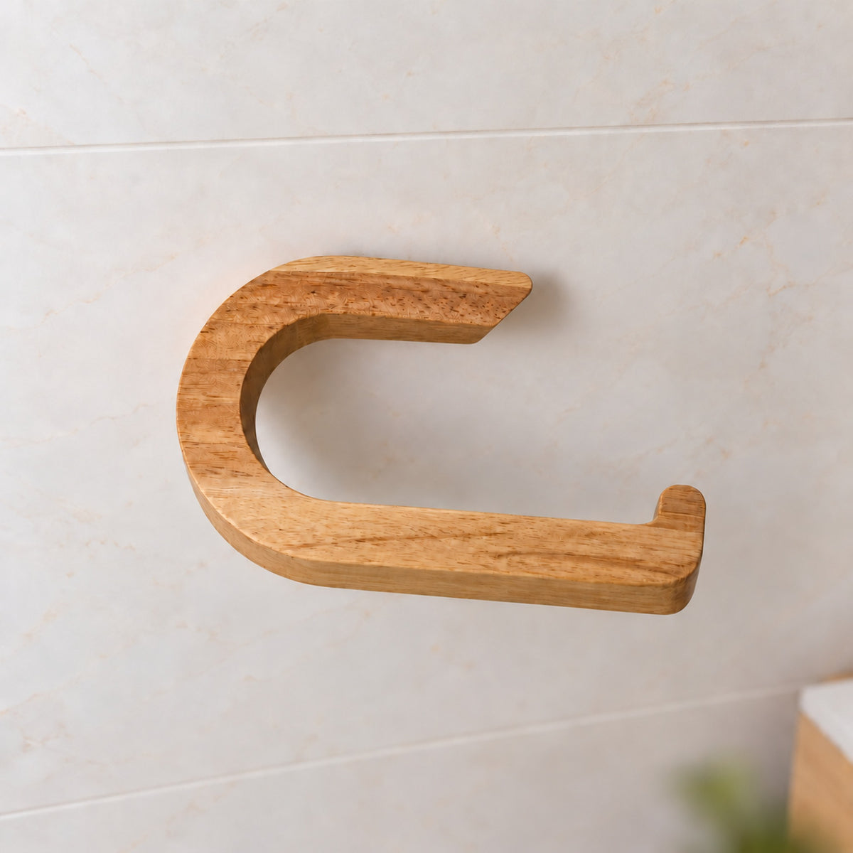 Nahaufnahme des leeren Toilettenpapierhalters aus Kautschukholz mit kurzem Wandarm und seitlich offener Rollenaufnahme.
